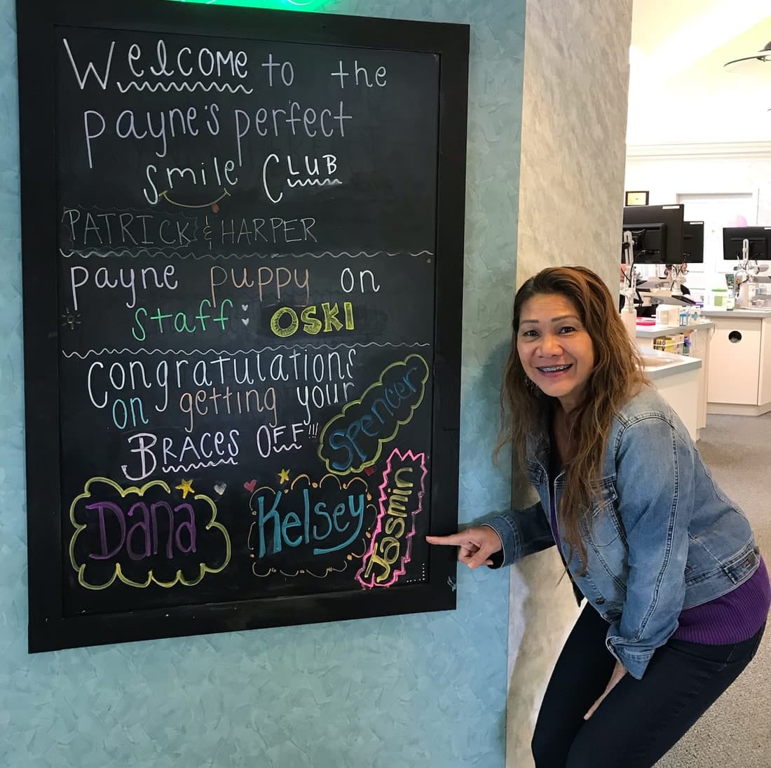 A Payne Orthodontics patient celebrating at the Perfect Smile Club board
